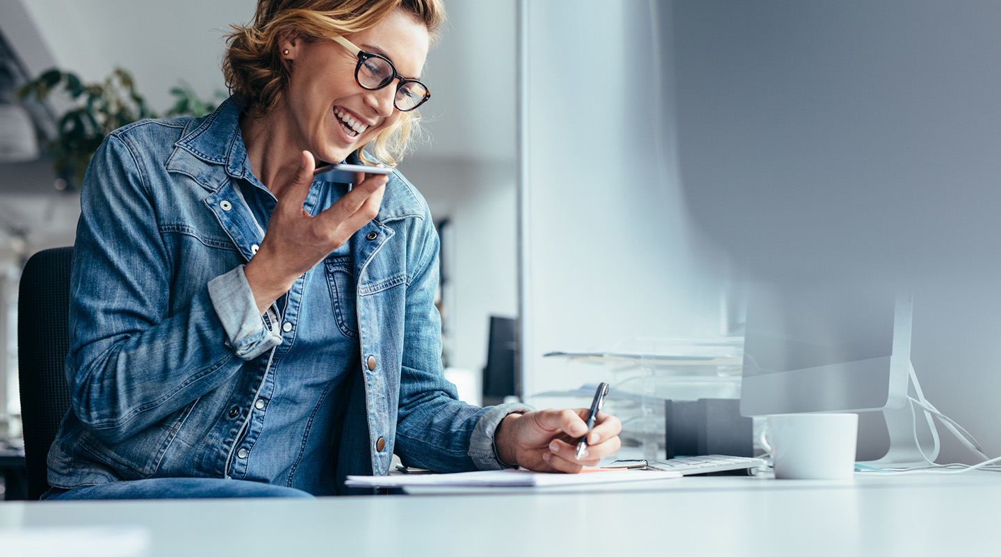 Woman at desk on cell phone